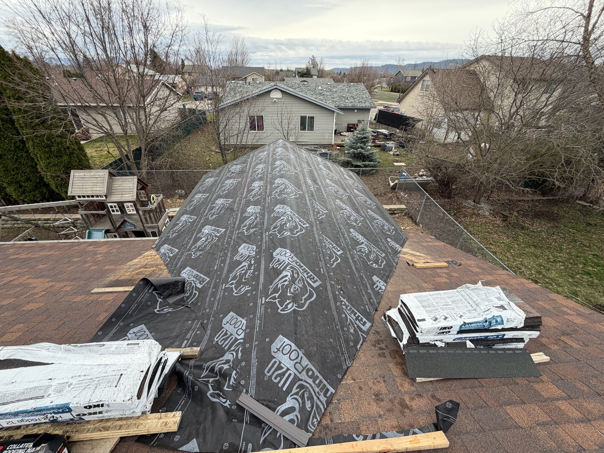 Roofing Rehab jobsite with underlayment and materials staged during a roof addition project