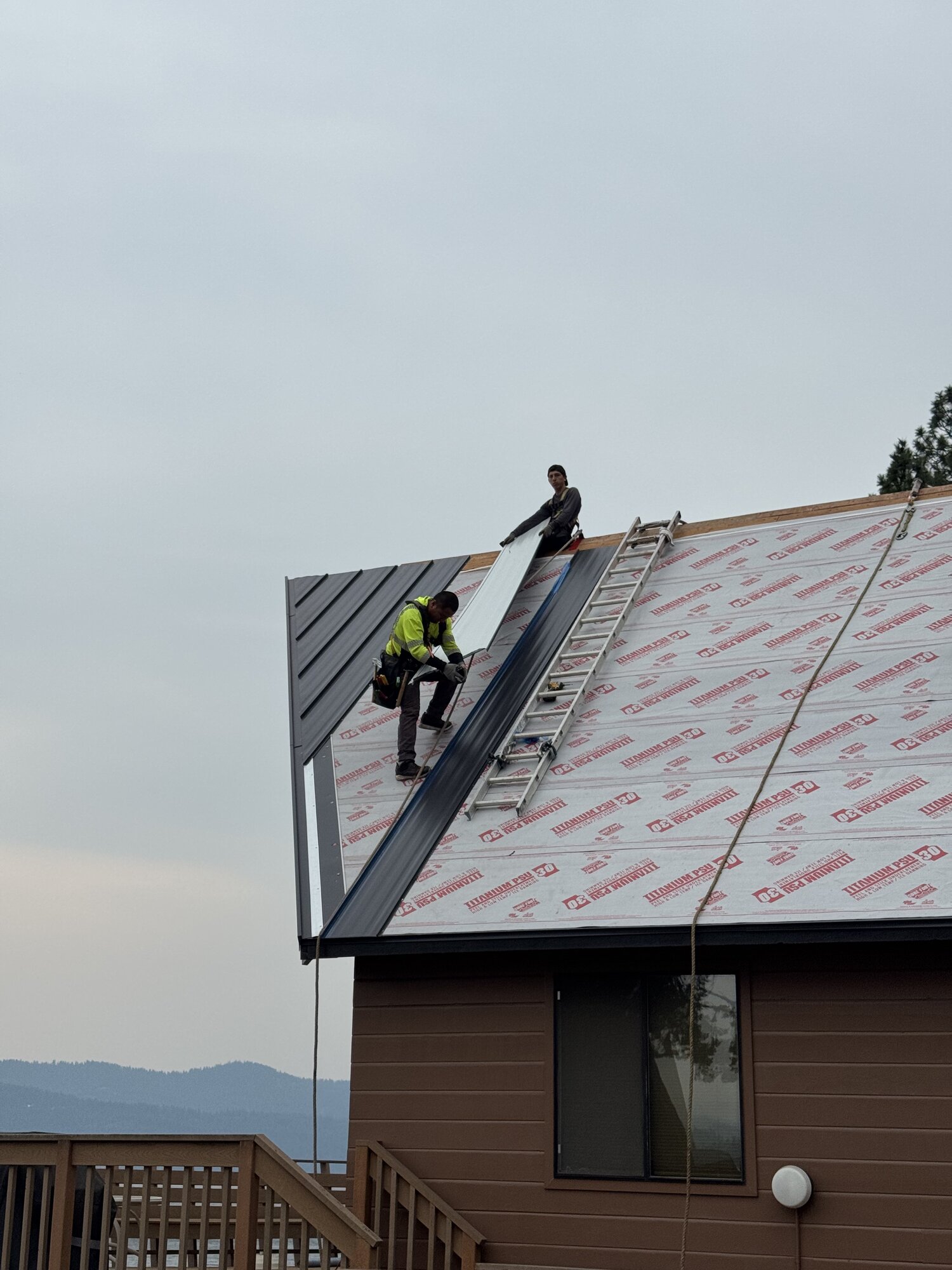 Roofing Rehab crew installing standing seam metal roofing